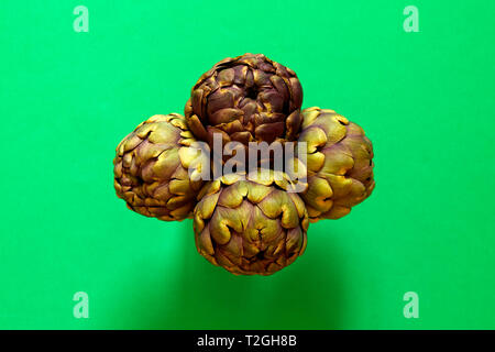 Gruppo di 4 carciofi isolato da sopra uno sfondo verde flatlay concept Foto Stock