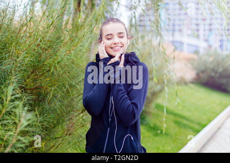 Ritratto di sportiva e attiva donna runner e ascolto di musica Foto Stock