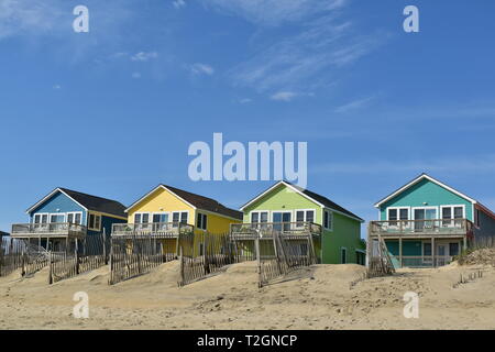 Case dai colori pastello su una spiaggia di dune Foto Stock