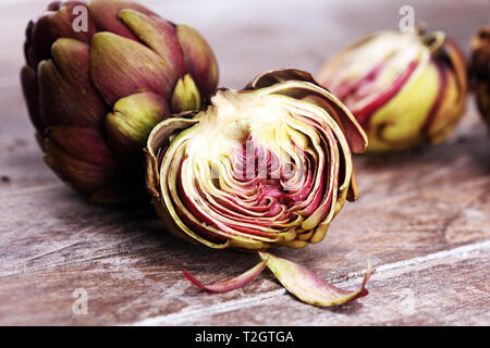 Carciofi su sfondo grigio. fresche biologiche fiore di carciofo. vegetale di carciofo Foto Stock