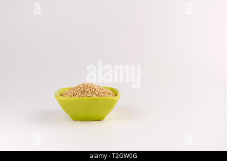La quinoa in coppa in ceramica isolata su sfondo bianco. Bianco crudo quinoa Foto Stock