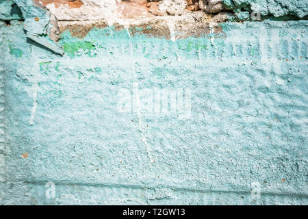 Un close-up di un frammento di una vecchia porta rurale. Recinzione in pietra dipinta in verde e la porta di metallo con ornamenti. Profondità di messa a fuoco, texture, sfondo Foto Stock