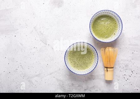 Vista superiore del tè verde Matcha in una ciotola su una superficie in calcestruzzo. È una ricca fonte di antiossidanti e polifenoli. Quando si prepara la polvere è parziale Foto Stock