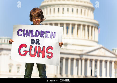 Bambino ragazzo protesta di fronte gli Stati Uniti Campidoglio in Washington Holding firmano dicendo i bambini o pistole Foto Stock