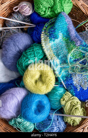 Balls of colourful wool in a knitting basket Foto Stock