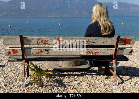 Il solitario fair lady sul banco di amore sul Lago di Garda Italia Foto Stock