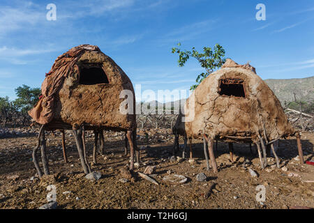 Primo piano di due tribù Himba case costruite di fango su palafitte in Damaraland Foto Stock