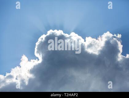 Sun dietro una nuvola in cielo blu, raggi risplendere, Germania Foto Stock