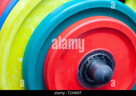 Closeup obright multicolore di manubri, barbells, pesi su supporto nella moderna palestra dell'hotel. Il concetto di uno stile di vita sano, perdita di peso, formazione bo Foto Stock