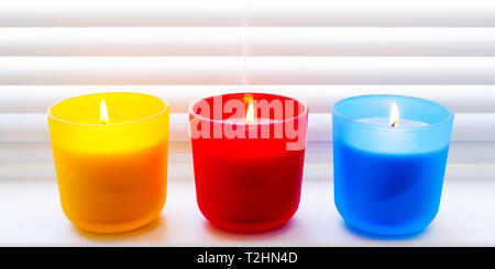 Luminose colorate candele. Profumate candele colorate con stoppini illuminato Foto Stock