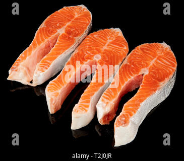 Tre crudo fresco di filetti di salmone isolate su bacground nero Foto Stock