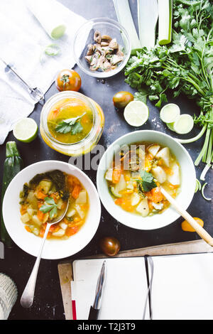 Il Minestrone ricetta, degustazione e la scrittura rcipe sul libro di cucina di italiano per il minestrone, sulla ciotola e jar con pomodoro ciliegino brown, calce e link roun Foto Stock