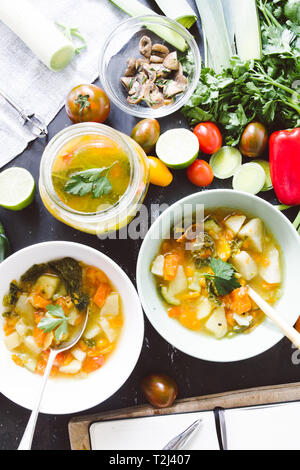 Il Minestrone ricetta, degustazione e la scrittura rcipe sul libro di cucina di italiano per il minestrone, sulla ciotola e jar con pomodoro ciliegino brown, calce e link roun Foto Stock