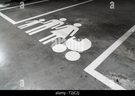 Parcheggio con la famiglia icona dipinta sul pavimento in calcestruzzo Foto Stock