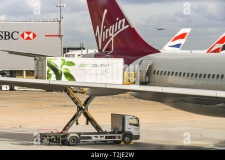 Dall'Aeroporto Heathrow di Londra, Inghilterra - Febbraio 2019: un Gate Gourmet elevatore a pantografo del carico del veicolo catering attraverso lo sportello posteriore di un Virgin Atlantic jet Foto Stock