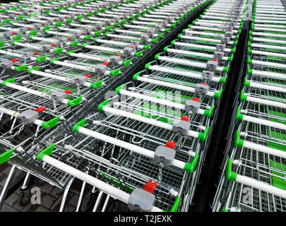 Righe di pronto per l'uso carrelli di shopping allineate in righe per lo stoccaggio vicino a un supermercato o hyper market Foto Stock