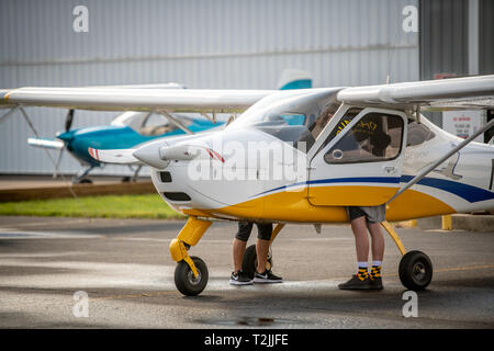 Vista laterale di due persone ispezionare cockpit di TECNAM P92 Eaglet aereo, Stevensville, MD Foto Stock