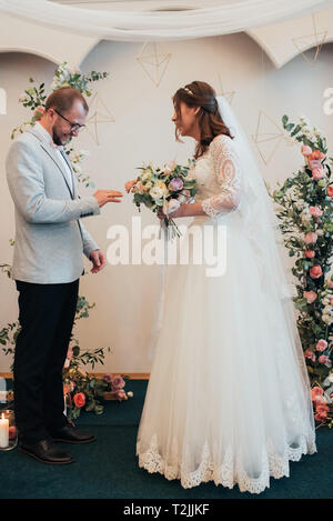 Sposa e lo sposo exchange matrimonio gli anelli in oro. Foto Stock