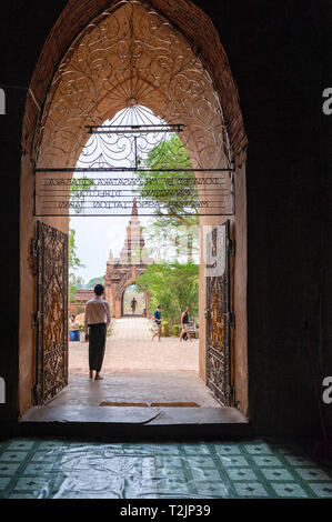 Tourguide in piedi all'ingresso di un tempio di Bagan Myanmar (Birmania) Foto Stock