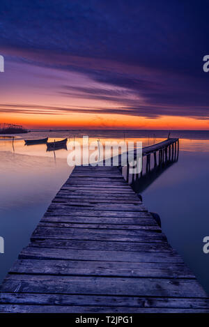 Pontoon usati dai pescatori per raggiungere le loro barche acquisiti prima del sorgere del sole con due barche da pesca in background e le ombre di uccelli in volo a causa t Foto Stock