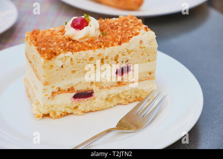 Fetta di corona di Francoforte la torta su una piastra bianca in una giornata di sole per esterno Foto Stock