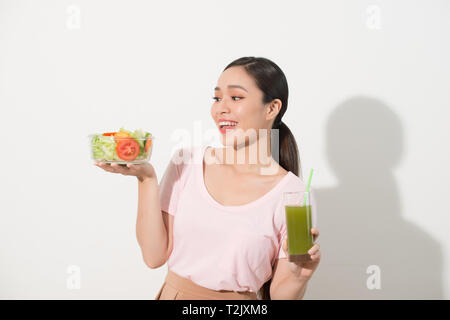 Donna con verde detox frullati, insalata in ciotola di vetro isolato su sfondo bianco. Una corretta alimentazione, cibo vegetariano, uno stile di vita sano, dieta conc Foto Stock