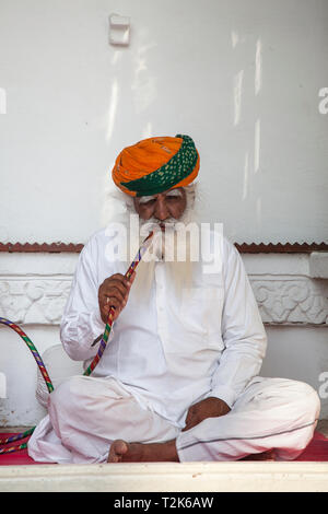 Uomo indiano con turbante fumare narghilè, Forte Mehrangarh, Jodhpur, Rajasthan, India Foto Stock