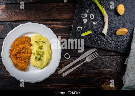 Pollo fritto bistecca o schnitzel con purè di patate sul tavolo di legno Foto Stock