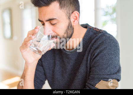 Uomo bello bere un fresco bicchiere di acqua Foto Stock