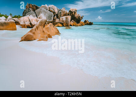 Rocce di granito di massi su Anse Cocos Beach, Seychelles. Pura sabbia bianca e acqua turchese, cielo blu. Vacanze viaggi concetto. Foto Stock