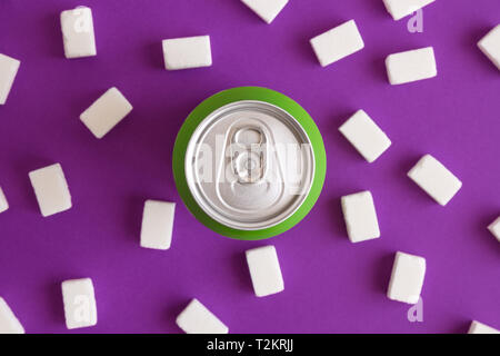 Lay piatto di alluminio può con cubetti di zucchero su sfondo viola creative minima cibo malsano concetto creativo. Foto Stock