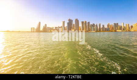 Paesaggio di Doha West Bay skyline dalla gita in barca nella baia di Doha alla luce del tramonto. Dhow di legno portano i turisti intorno alla baia. Il Qatar, Medio Oriente, Arabo Foto Stock