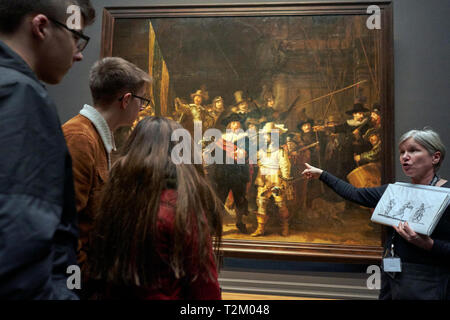 I visitatori del Museo Rijks osservare il dipinto 'Ronda di Notte" di Rembrandt. Il 2019 segna il 350° anniversario di Rembrandt la morte. Foto Stock