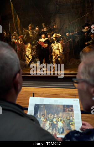 I visitatori del Museo Rijks osservare il dipinto 'Ronda di Notte" di Rembrandt. Il 2019 segna il 350° anniversario di Rembrandt la morte. Foto Stock