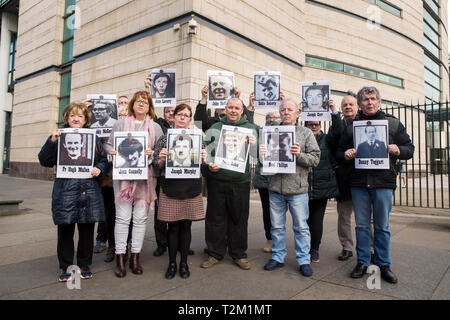 Le famiglie di coloro che sono stati uccisi durante la contestazione di un serie di tiri in Ballymurphy zona di Belfast nell' Agosto 1971 mantenere immagini dei loro cari con i sostenitori al di fuori di Belfast Laganside tribunali, Irlanda del Nord, durante una nuova inchiesta su i loro cari morti. Foto Stock