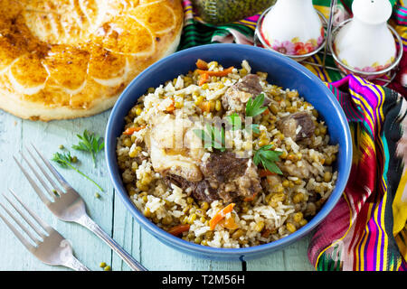 Cucina Araba. Eventi del Ramadan. Medio Oriente (Mashkichiri porridge realizzato di riso, carne di manzo e di Mung bean) su un tavolo di legno. Foto Stock