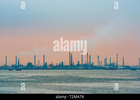 Raffineria di petrolio al tramonto su Bukom isola di Singapore Foto Stock