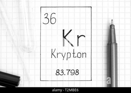 Tavola periodica degli elementi. La grafia elemento chimico cripton Kr con la penna nera, tubo di prova e la pipetta. Close-up. Foto Stock