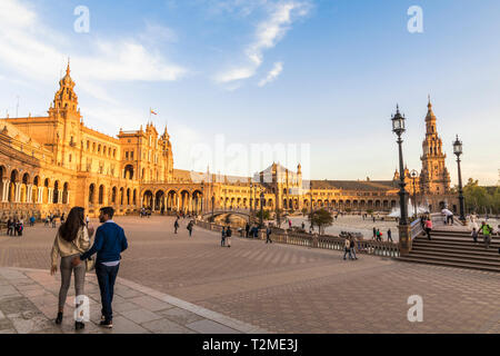 Siviglia, Spagna. Un paio di passeggiate al tramonto nella Plaza de Espana (Piazza di Spagna), un importante punto di riferimento nella città di Siviglia progettato da Anibal Gonzalez Foto Stock