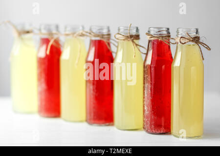 Deliziosi agrumi e melograno limonata in bottiglie di vetro. Concetto di bevande, estate, bar, di riposo e di cibo sano Foto Stock