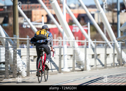 L'uomo vanno in bicicletta sul ponte andare al luogo di lavoro attivo che preferiscono uno stile di vita sano e un'alternativa ecocompatibile modalità di trasporto i Foto Stock