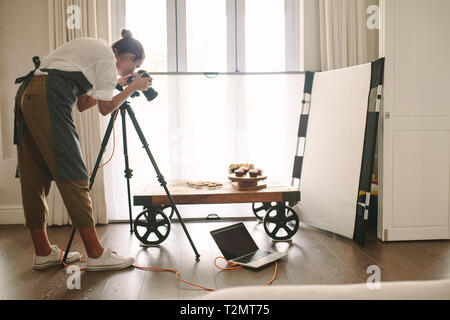 Professional blogger alimentare per scattare foto di oggetti di pasta sulla tavola con fotocamera reflex digitale. Fotografo femmina a scattare foto di cibo dolce, telecamera montata Foto Stock