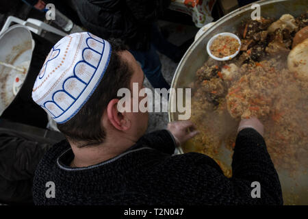 Cuocere in chapan e zucchetto preparazione pilaf in un paiolo di rame su strada Foto Stock