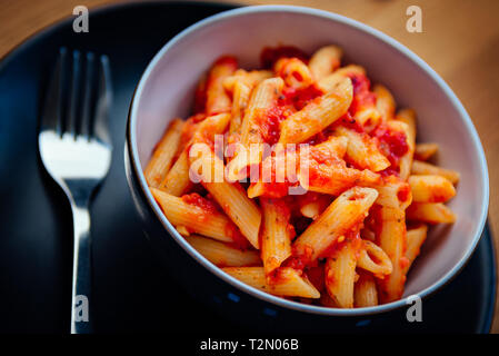 Una ciotola piena di casalingo italiano penne la pasta con la salsa di pomodoro Foto Stock