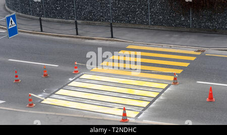 Isolato dipinta di fresco strada pedonale crosswalk luminoso con vernice gialla per la circolazione su strada e per la sicurezza del traffico in un villaggio svizzero Foto Stock