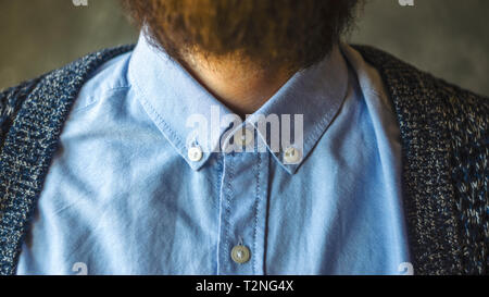 Uomo Barbuto in maglietta blu e Cardigan. Close-up del collare della camicia e del collo. I dettagli di abbigliamento Foto Stock