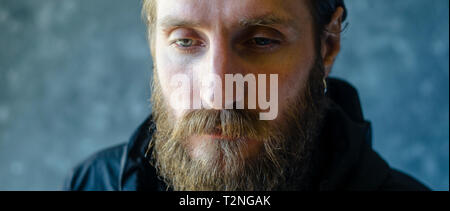 Ritratto di un grave triste con barba. Raccolto di qualità cinematografica. Uomo Thinkness Concept Foto Stock