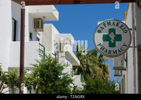 Farmacia segno con un serpente intorno alla vaschetta e la scritta "farmacia" in inglese e greco Foto Stock