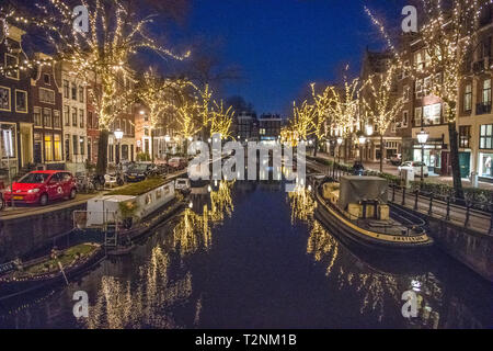 Bellissimi alberi luminosi la linea Amsterdam canal soprannominato "Venezia del Nord" che conduce al Rijksmuseum una storia olandese museum di Amsterdam, Net Foto Stock