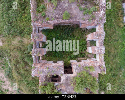 Vista di un abbandonato edificio di mattoni con un drone, una foresta cresce all'interno Foto Stock